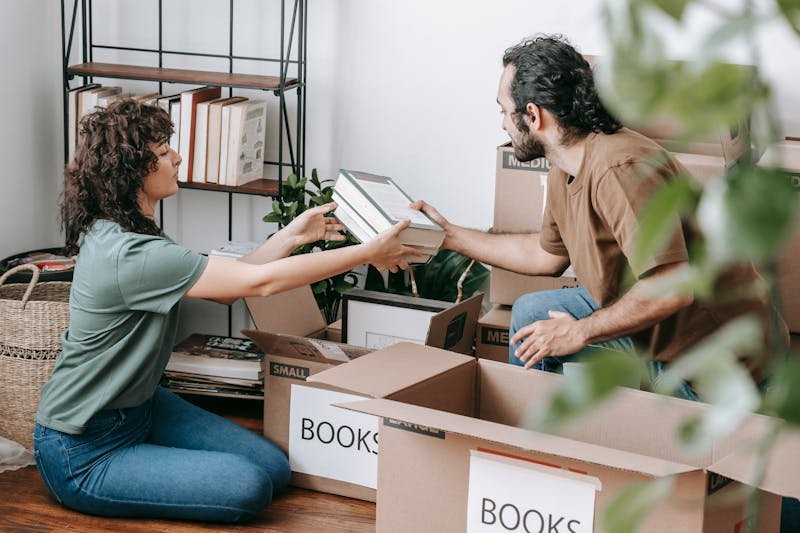 Couple packing books and belongings